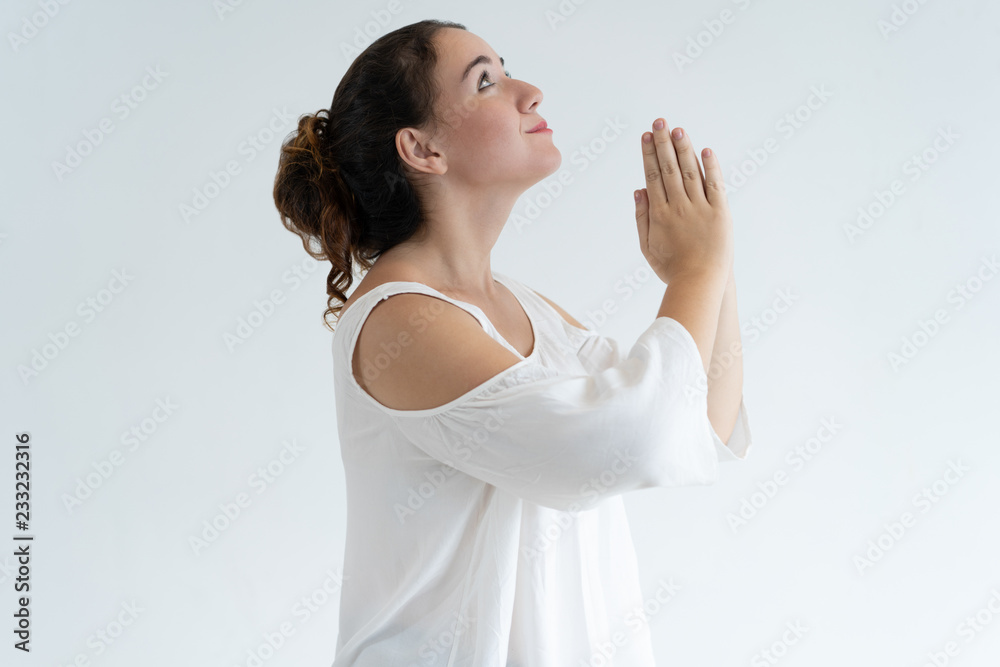 Positive lovely woman holding hands together and praying. Young lady  begging for something. Prayer concept. Isolated side view on white  background. Stock Photo | Adobe Stock