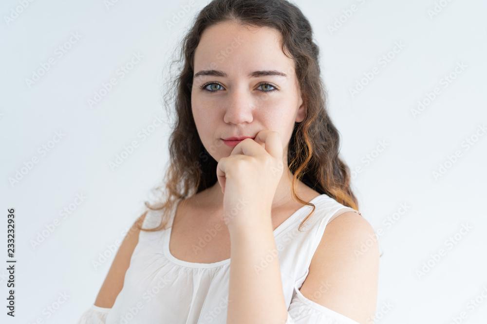 Face of curious young girl looking at camera and smiling. Close-up of pretty woman looking at camera with hand on chin Face of curious young girl looking at camera and smiling. Close-up of pretty woman looking at camera with hand on chin