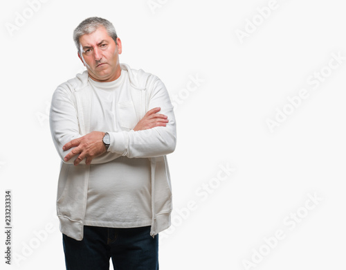 Handsome senior man wearing sport clothes over isolated background skeptic and nervous, disapproving expression on face with crossed arms. Negative person.