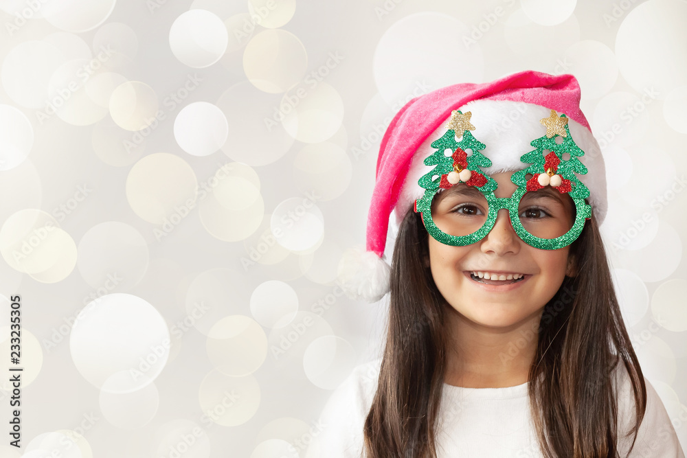 Christmas time - happy cheerful child girl in Santa Claus Hat and festive new year glasses. Christmas time - happy cheerful child girl in Santa Claus Hat and festive new year glasses.