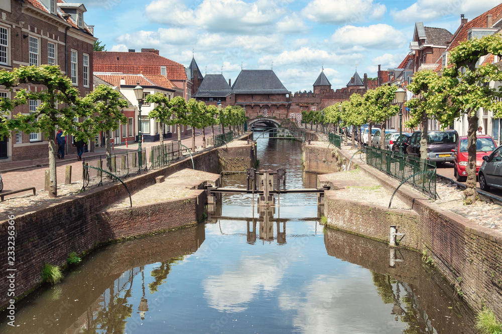 Fototapeta premium The canal Eem with in the background the medieval gate The Koppelpoort in the Dutch city of Amersfoort