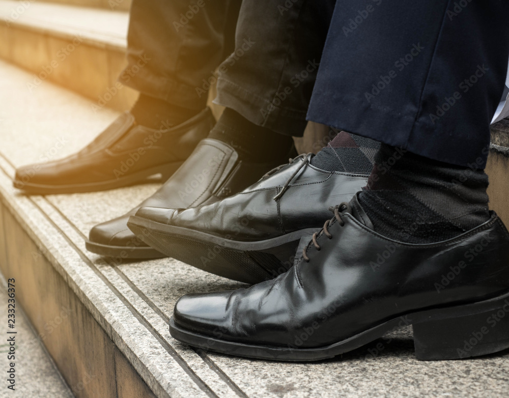 Leather shoes of two business people sit on the stairs. Leather shoes of two business people sit on the stairs.
