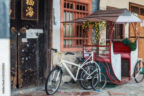 Old white bicycle and wagon in a street of George town, Penang. 