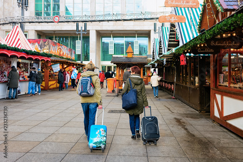 People with luggage bags and backpacks Christmas Market Alexanderplatz Berlin