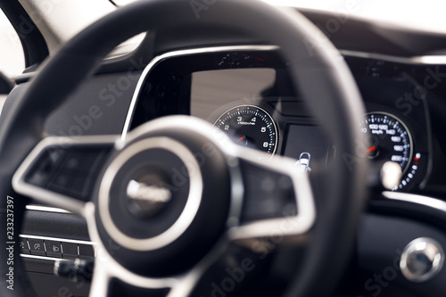 Close-up of a modern dashboard in an expensive car. The steering wheel is blurred. Advanced technology concept