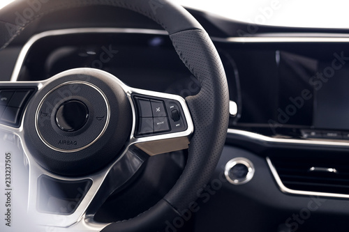 Multimedia leather steering wheel in a modern expensive car. Perforated leather steering wheel. Modern car interior details. Car detailing. Selective focus