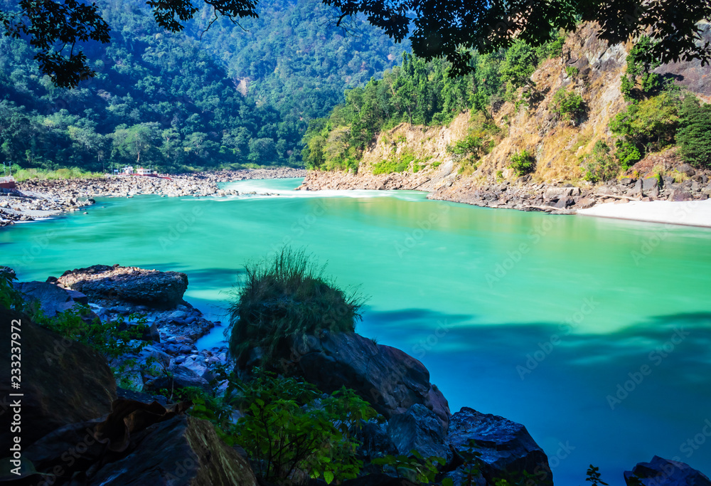 seemless flow of river ganges in the daylight. rishikesh. enjoy view at foolchati with sand and rocks in background