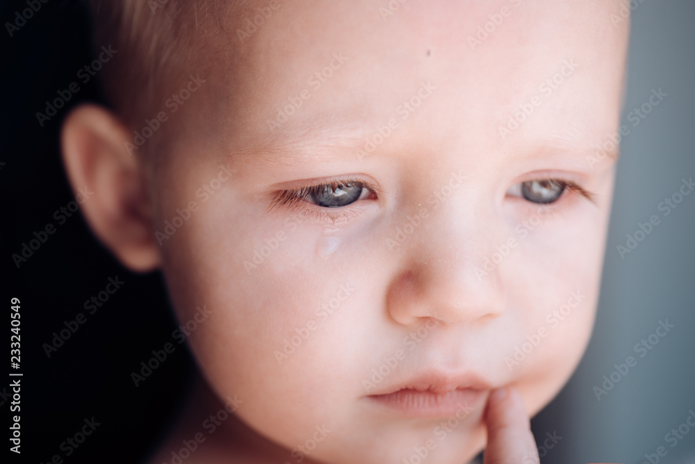 Unhappy cutie. Baby with tear rolling down his cheek. Little baby crying. Little boy child with sad face. He is a cry baby Unhappy cutie. Baby with tear rolling down his cheek. Little baby crying. Little boy child with sad face. He is a cry baby