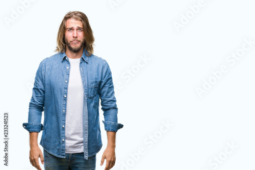 Young handsome man with long hair over isolated background depressed and worry for distress, crying angry and afraid. Sad expression.