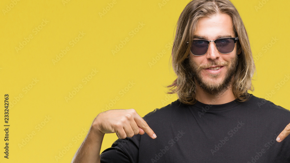 Young handsome man with long hair wearing sunglasses over isolated background looking confident with smile on face, pointing oneself with fingers proud and happy. Young handsome man with long hair wearing sunglasses over isolated background looking confident with smile on face, pointing oneself with fingers proud and happy.