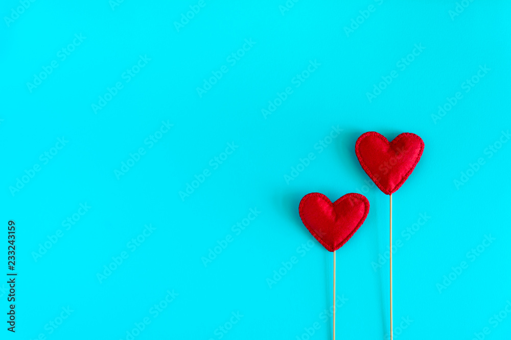 Felt love hearts on booth props on blue paper background. Valentine's day celebration concept. Top view. Flat lay. Copy space