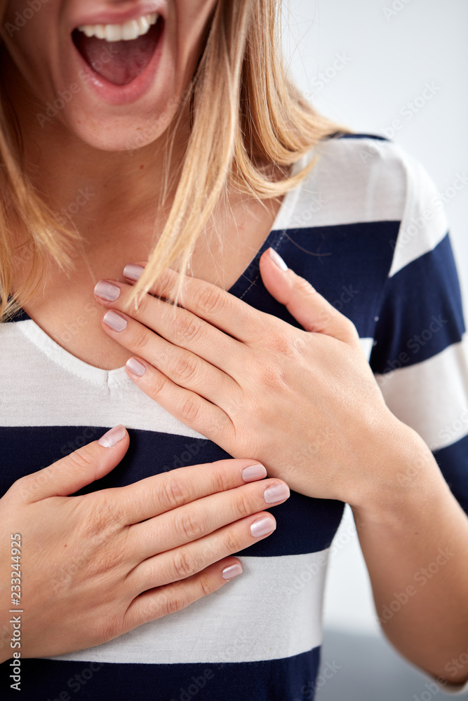 Young woman with heart problem holding chest.