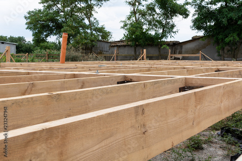 Wooden frame house construction. Wooden flooring base under construction.