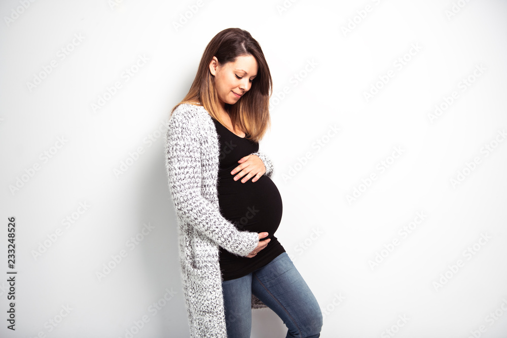 A Portrait of happy pregnant woman with hands on stomach isolated over white background A Portrait of happy pregnant woman with hands on stomach isolated over white background