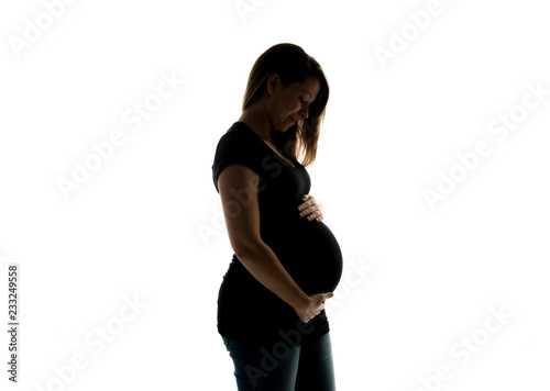Shadow Portrait of happy pregnant woman with hands on stomach isolated over white background