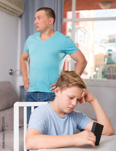 Man with his son are conflicting and boy playing with phone
