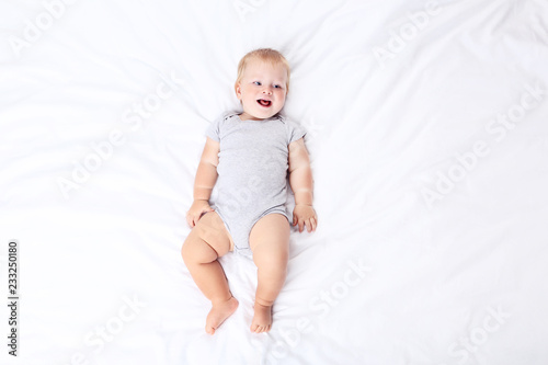 Little boy lying on white bed