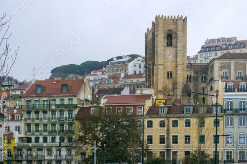 The bell tower of the Lisbon cathedral between the traditional buildings of the Alfama district, Portugal