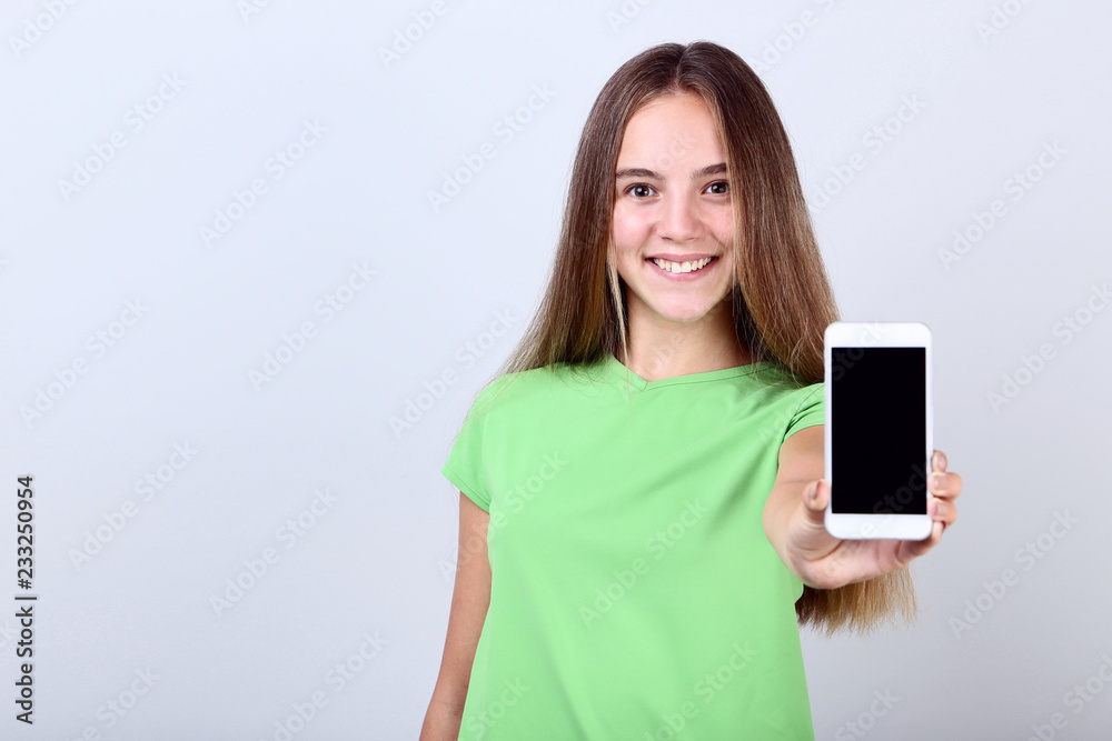 Fototapeta premium Beautiful girl with smartphone on grey background