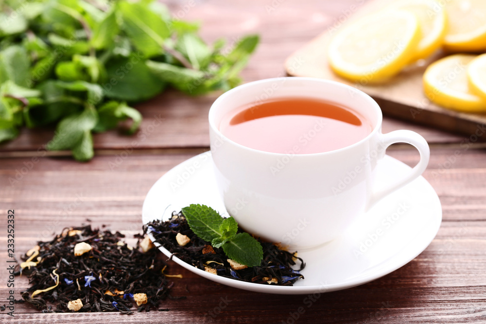 Cup of tea with mint leafs on brown wooden table Cup of tea with mint leafs on brown wooden table