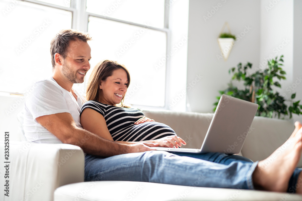 A Couple With Pregnant Woman Using Laptop Computer Together