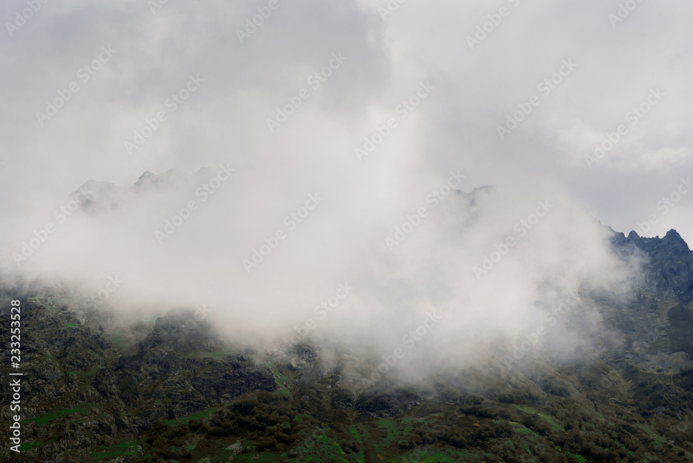 background - the clouds cover the mountain slope in the highlands
