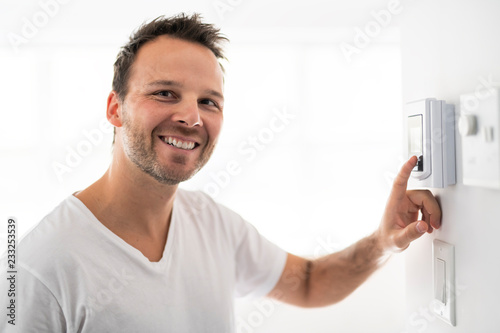A man set the thermostat at house photo