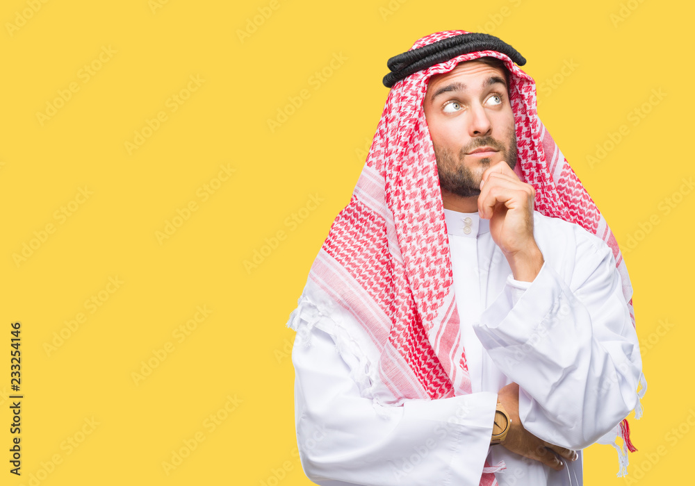 Young handsome man wearing keffiyeh over isolated background with hand on chin thinking about question, pensive expression. Smiling with thoughtful face. Doubt concept.