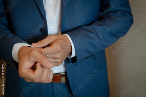 the man corrects cuffs on a sleeve