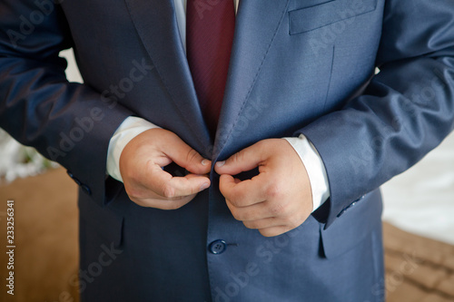 the man buttoning hands a jacket