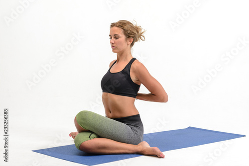 Beautiful young woman doing yoga on white background