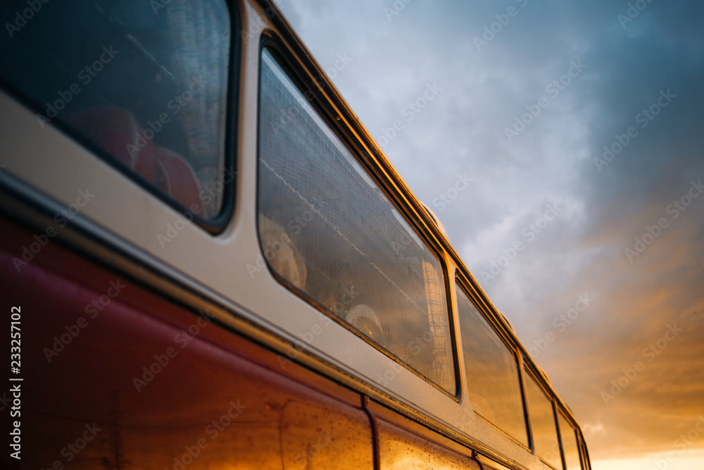 Old classic bus windows with reflection of sunset