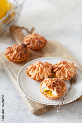 lemon custard tarts with meringue on white background