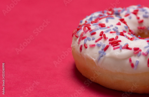 closeup of a donut on a bright red background