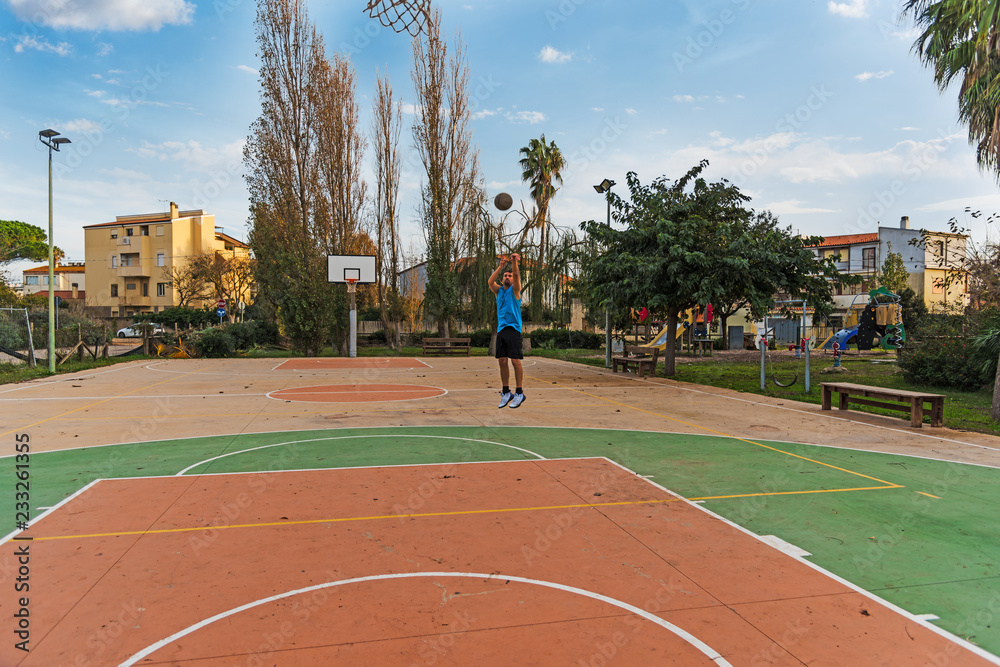 Fototapeta premium Basketball player working out in a outdoor court
