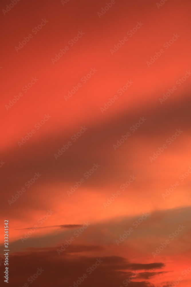 Vibrant orange color gradation and cloud layer of the sunrise sky