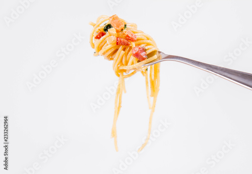 Spaghetti Carbonara with some parsley on a fork on a white background
