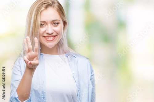 Young blonde woman over isolated background showing and pointing up with fingers number three while smiling confident and happy.