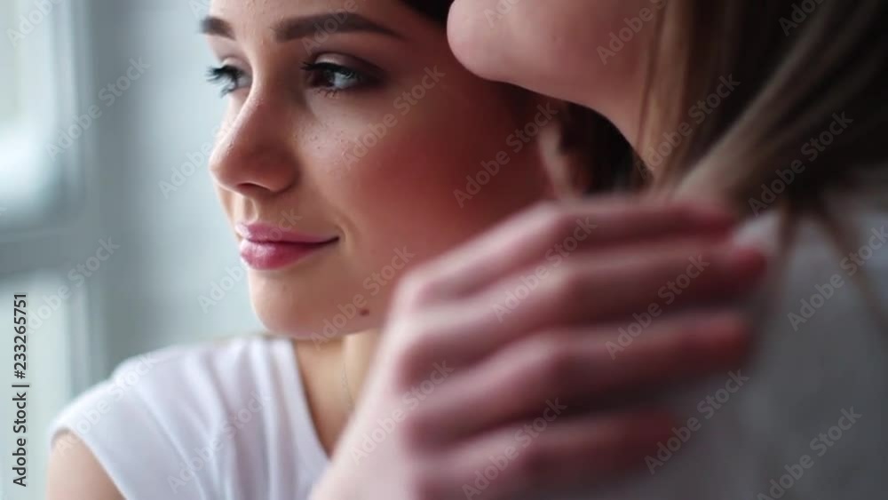 Face daughter hugging mom showing love and affection in white studio hold hands family mother together young camera teenager close up slow motion