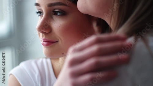 Face daughter hugging mom showing love and affection in white studio hold hands family mother together young camera teenager close up slow motion