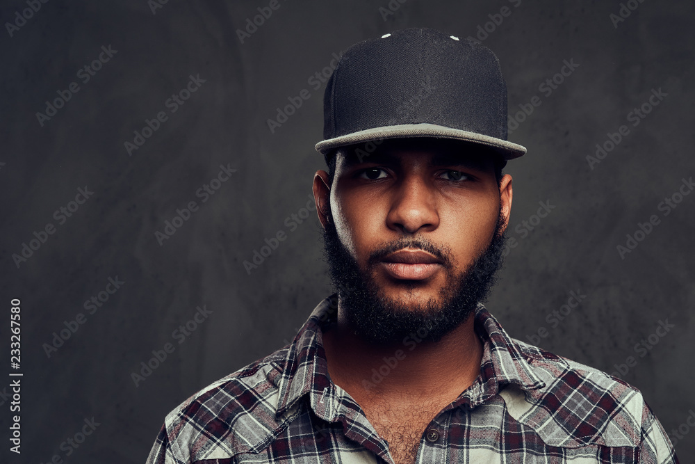 African-American guy wearing a checkered shirt and cap African-American guy wearing a checkered shirt and cap