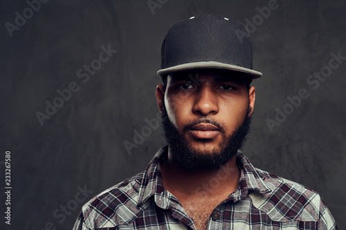 African-American guy wearing a checkered shirt and cap