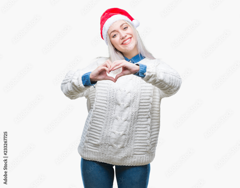 Young blonde woman wearing christmas hat over isolated background smiling in love showing heart symbol and shape with hands. Romantic concept. Young blonde woman wearing christmas hat over isolated background smiling in love showing heart symbol and shape with hands. Romantic concept.