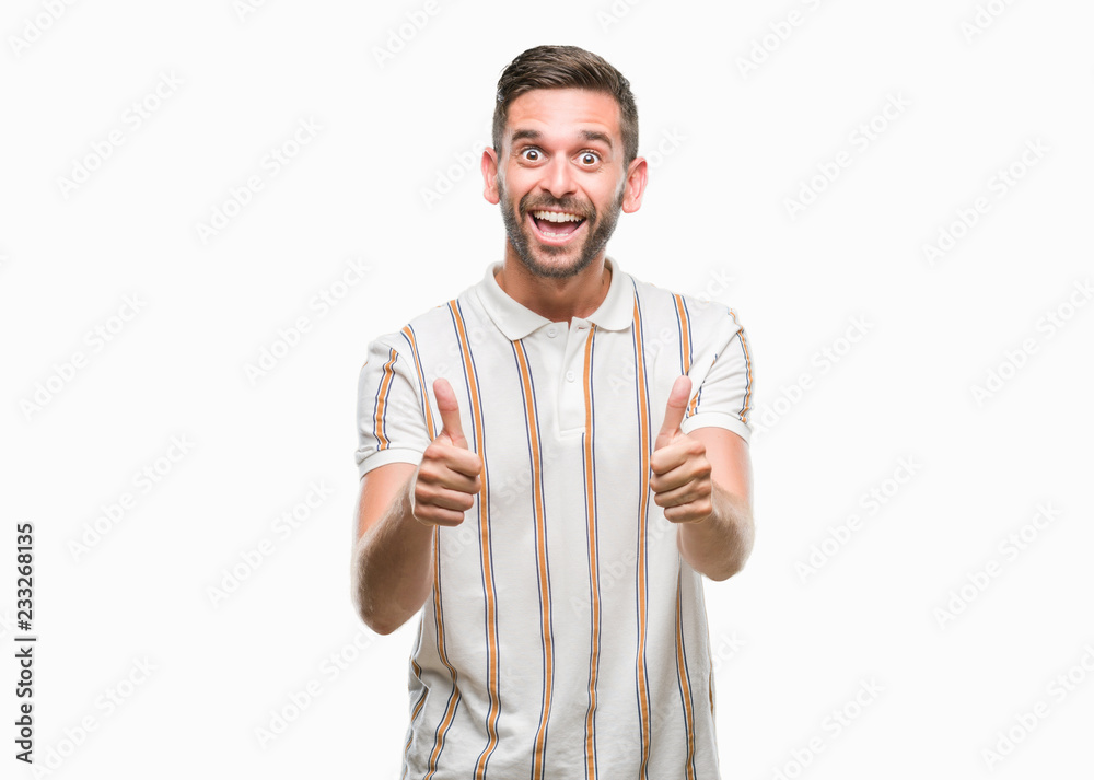 Young handsome man over isolated background doing happy thumbs up gesture with hand. Approving expression looking at the camera with showing success. Young handsome man over isolated background doing happy thumbs up gesture with hand. Approving expression looking at the camera with showing success.