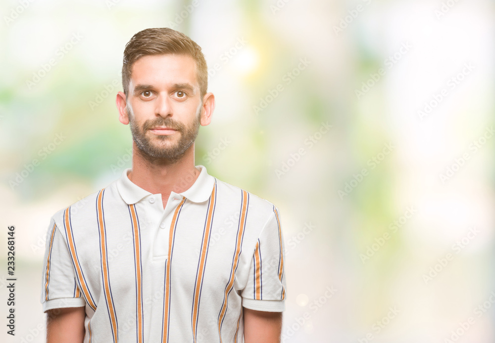 Young handsome man over isolated background with serious expression on face. Simple and natural looking at the camera. Young handsome man over isolated background with serious expression on face. Simple and natural looking at the camera.