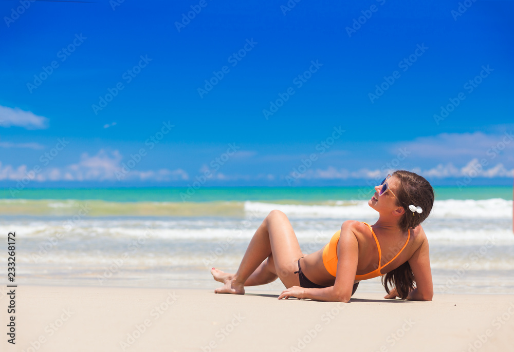 younglong haired girl in bright bikini tanning at tropical beach younglong haired girl in bright bikini tanning at tropical beach