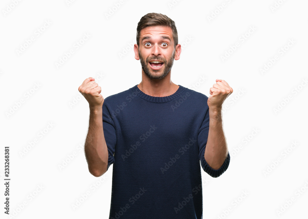 Fototapeta premium Young handsome man wearing winter sweater over isolated background celebrating surprised and amazed for success with arms raised and open eyes. Winner concept.