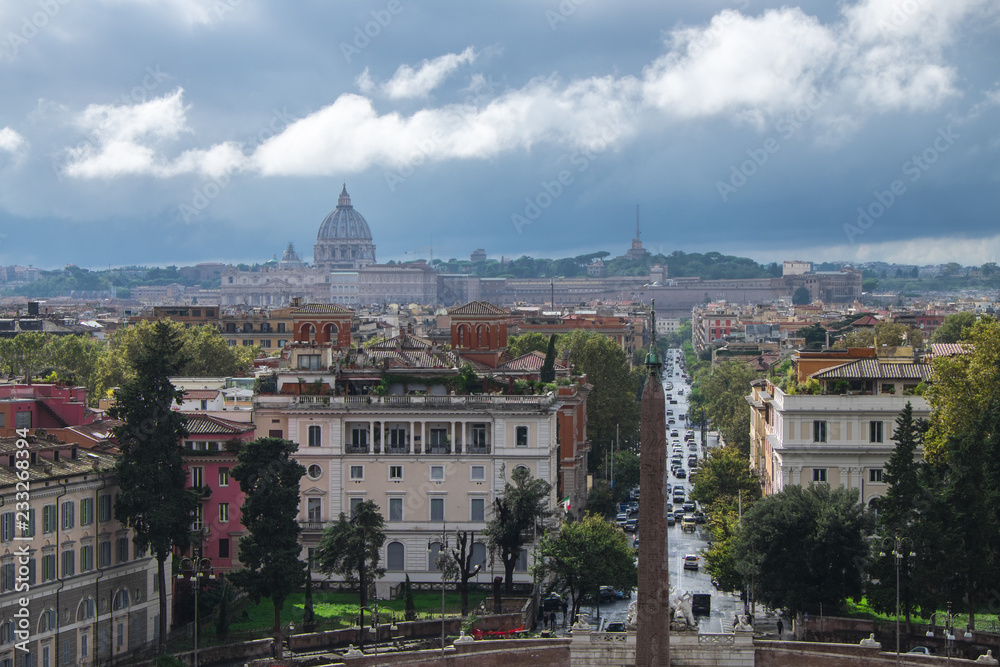The view of Rome with Sain Peter's Dome in the distance under the grey stormy and cloudy sky, shot from a high point - Terazza del Pincio
