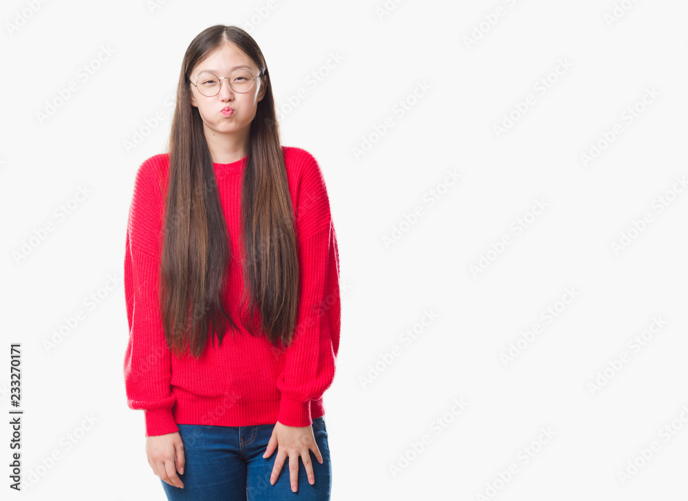 Young Chinese woman over isolated background wearing glasses puffing cheeks with funny face. Mouth inflated with air, crazy expression. Young Chinese woman over isolated background wearing glasses puffing cheeks with funny face. Mouth inflated with air, crazy expression.