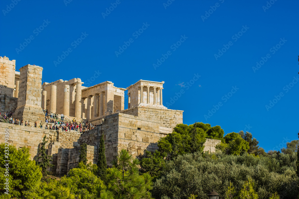 tourism agency concept banner shot of crowd of tourists people in touristic place antique ancient temple ruins on empty blue sky background, copy space  